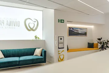 Sala de espera con sofá y banco tapizado · Clínica Dental Divina Pastora, Ansoáin